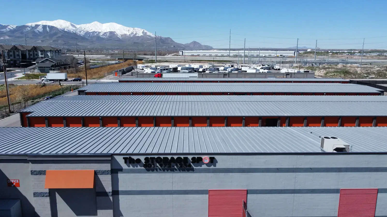 The Storage Spot steel self-storage facility aerial in West Valley City, Utah, with snowcapped Wasatch peaks