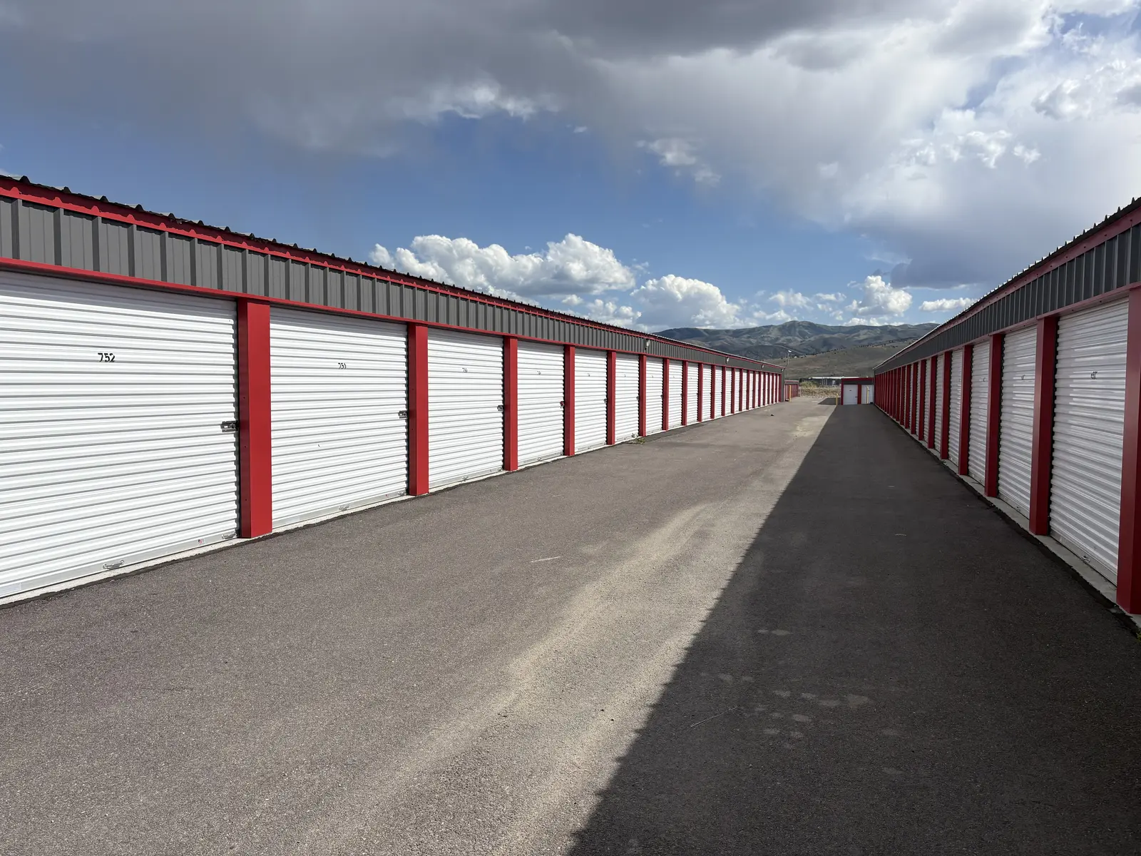 Drive aisle between pre-engineered metal self-storage buildings with mountains, Chubbuck ID
